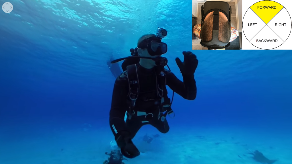 Audio Description: A small bait box hangs from the boat by a thin cable. As you descend, your diving partner stares back at you and waves his hand. He has a camera attached to his head.