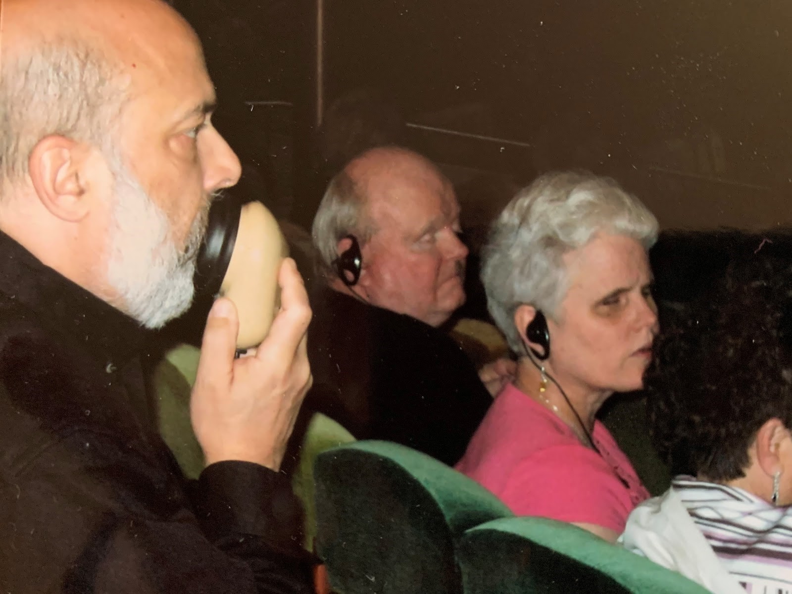 Dr. Snyder providing audio description at a live theatrical presentation for AD consumers Berl and Denise Colley.