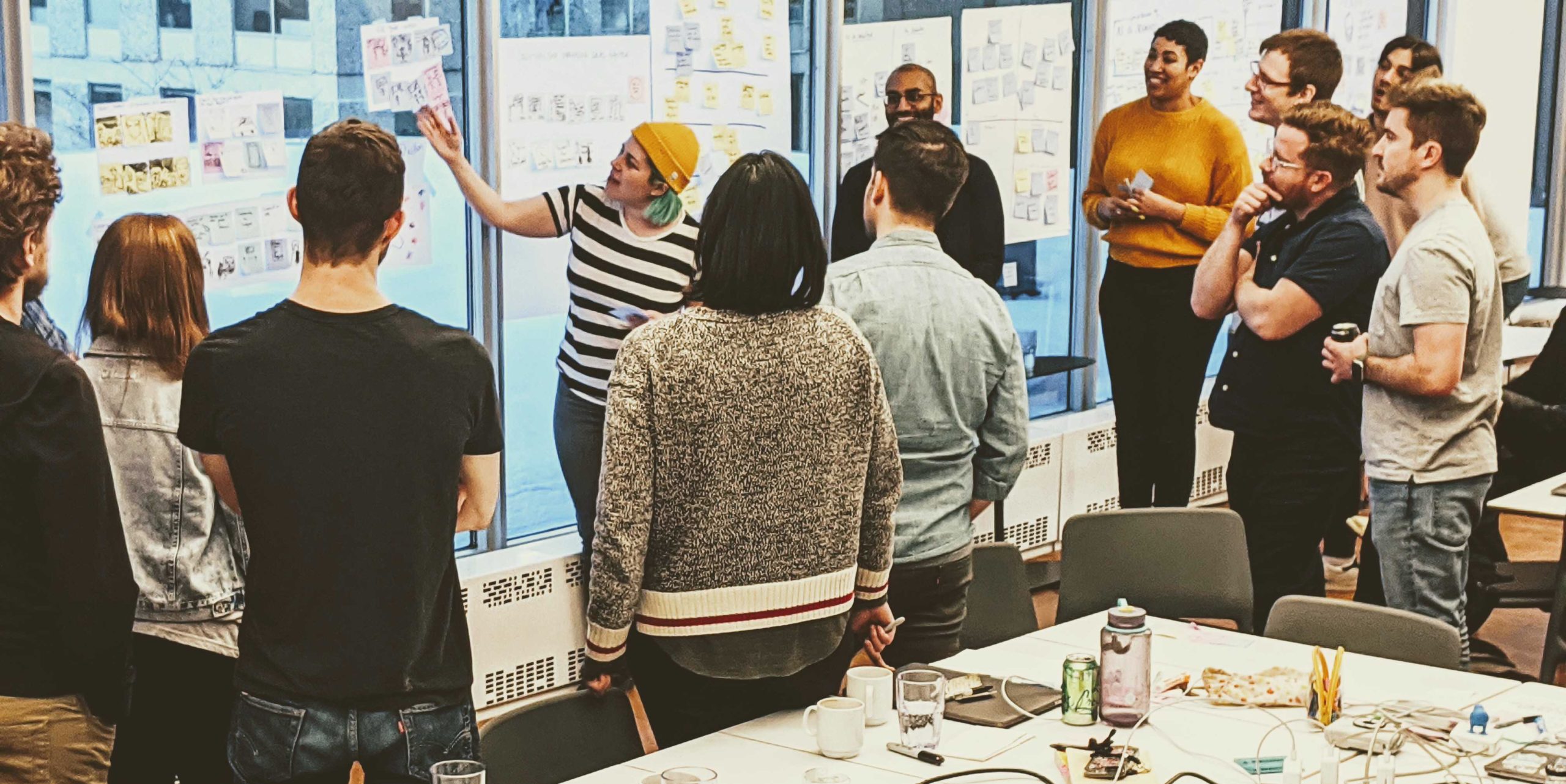 Devon Persing pictured in a yellow hat working with colleagues on the Polaris team at Shopify.
