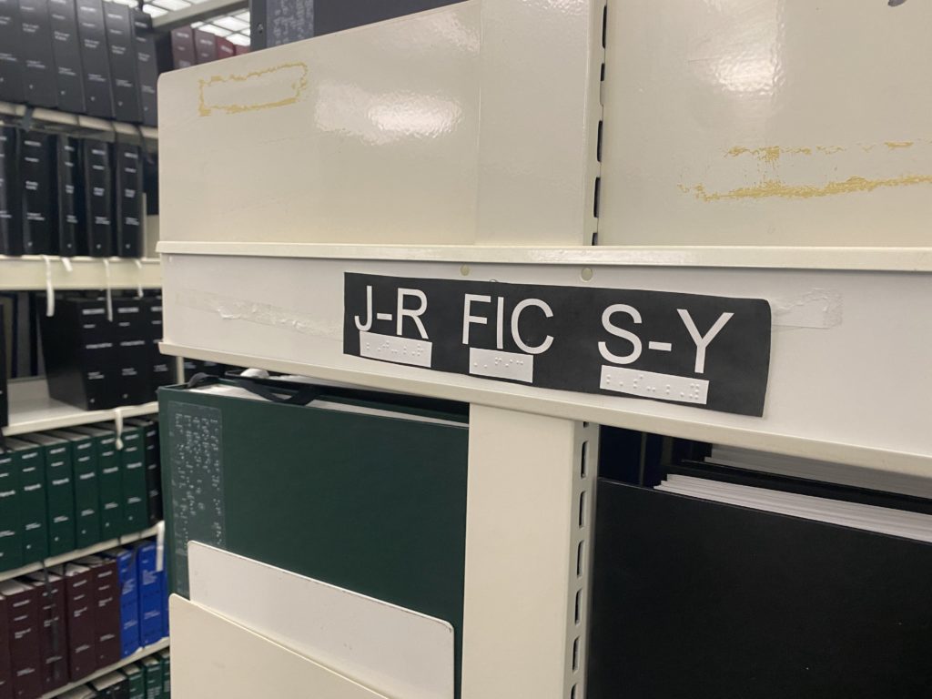 End of book stack showing J-R, FIC, S-Y with Braille under each