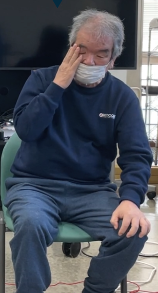 After removing the headset, a participant puts their hand on their eye looking tired.